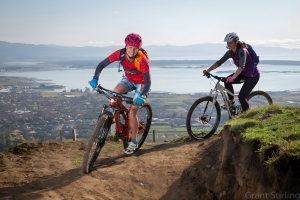 Two women cycle along a mountain bike trail