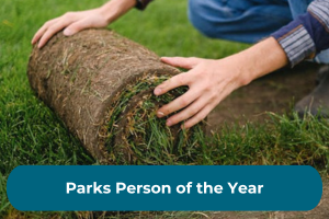 A person rolls a piece of turf out with the copy 'Parks Person of the Year'