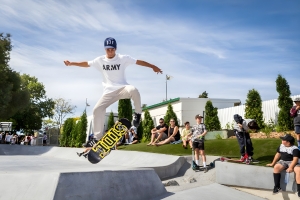 A kid does an ollie on a skateboard, he's at a skatepark